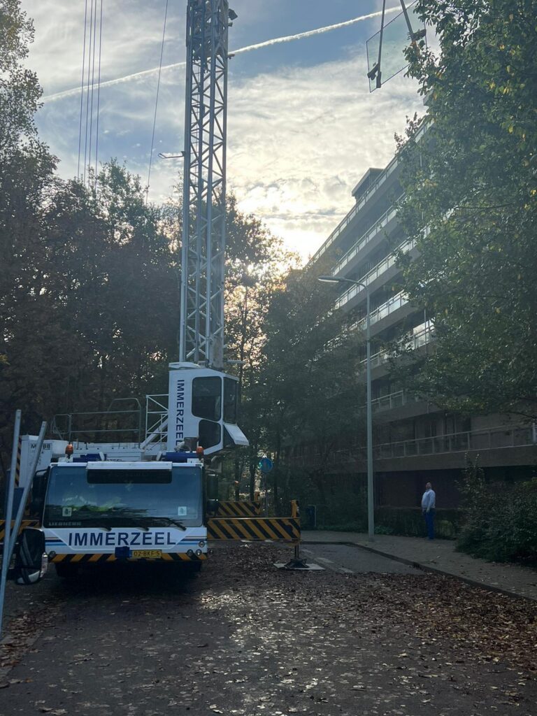 Mobiele glazetterskraan in woonstraat Den Haag voor glasmontage op hoogte