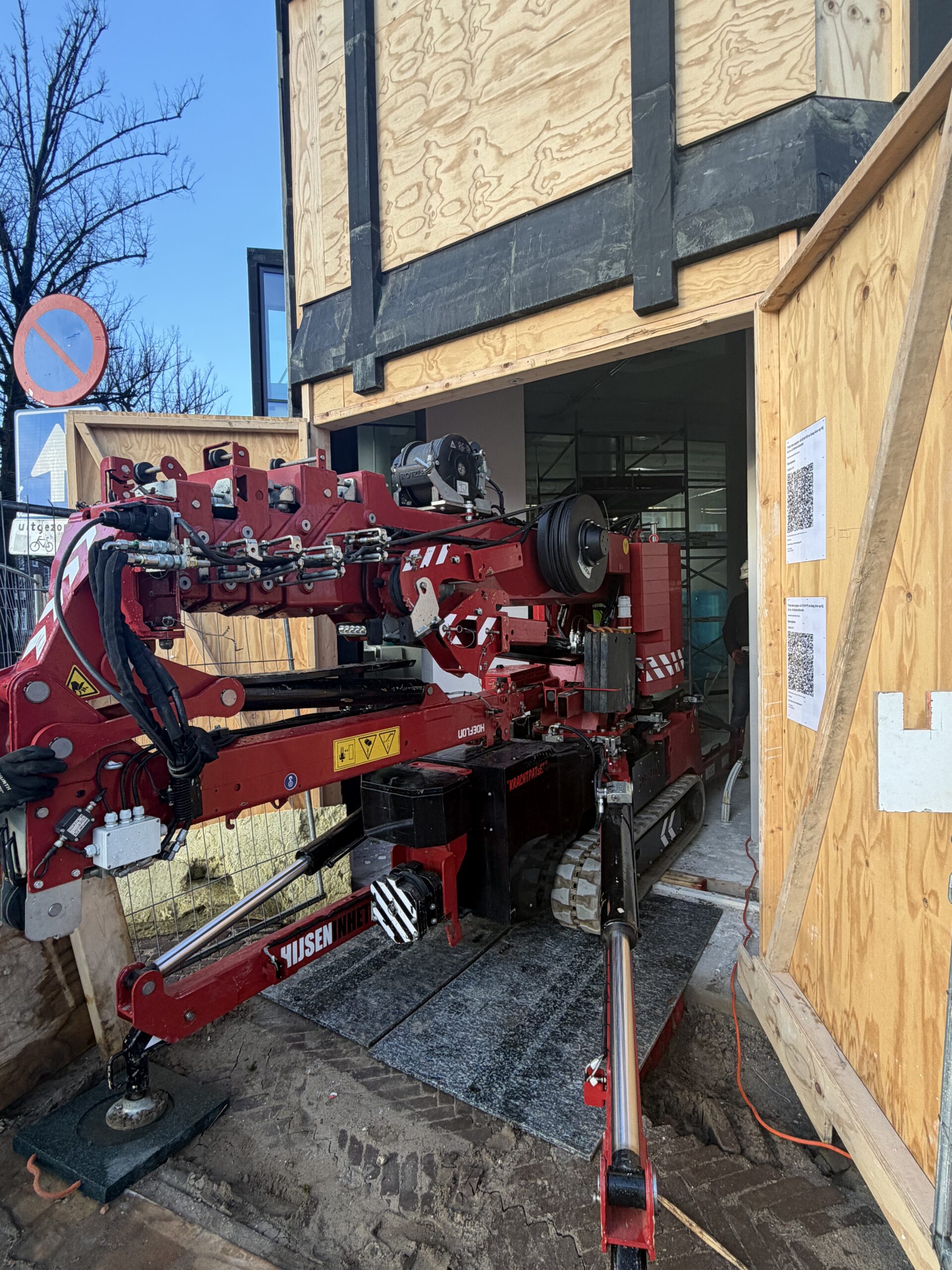 Hoeflon minikraan voor pand met houten gevel klaar voor glasmontage werkzaamheden